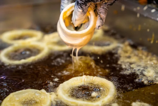 Onion rings being lowered into the fryer