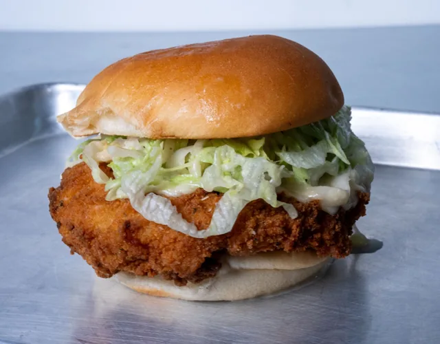 A crispy chicken sandwich with creamy dressing and lettuce
