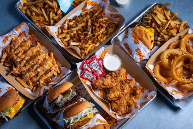 An overhead spread of burgers, fries, onion rings and tenders