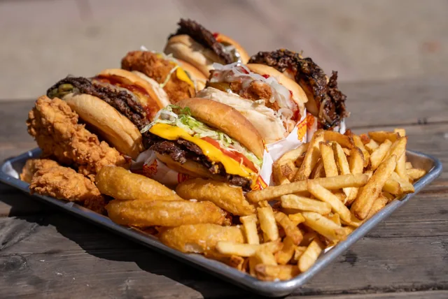 Burgers, tenders and sides ready to share on a picnic table